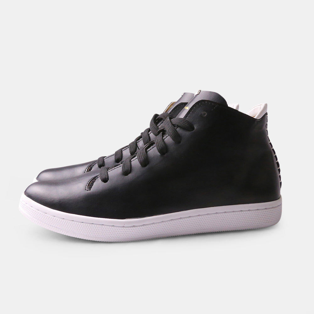 Quarter view of a black leather mid-top lace up sneaker with a white cupsole and white heel accents