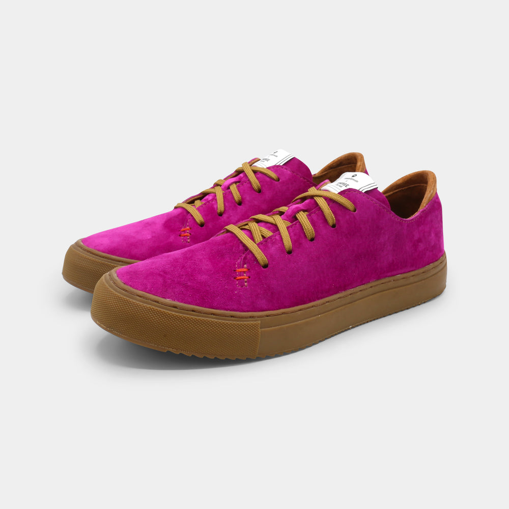 A pink low-top sneaker with a brown sole and laces, quarter view.