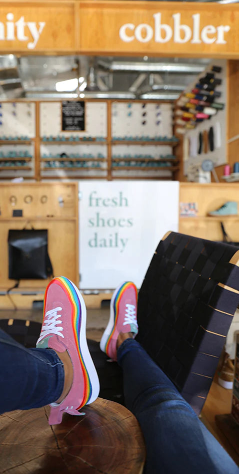 rainbow westsiders worn in front of a comunitymade sign