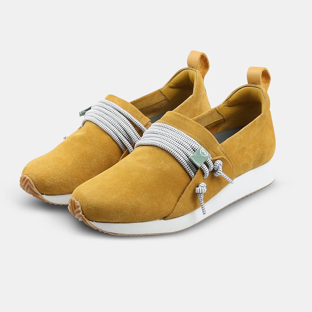 A quarter profile picture of a brown suede COMUNITYmade Mateo sneaker with a white sole and lace-up closure, white midsole and gum rubber outsole and a leather heel loop pull tab