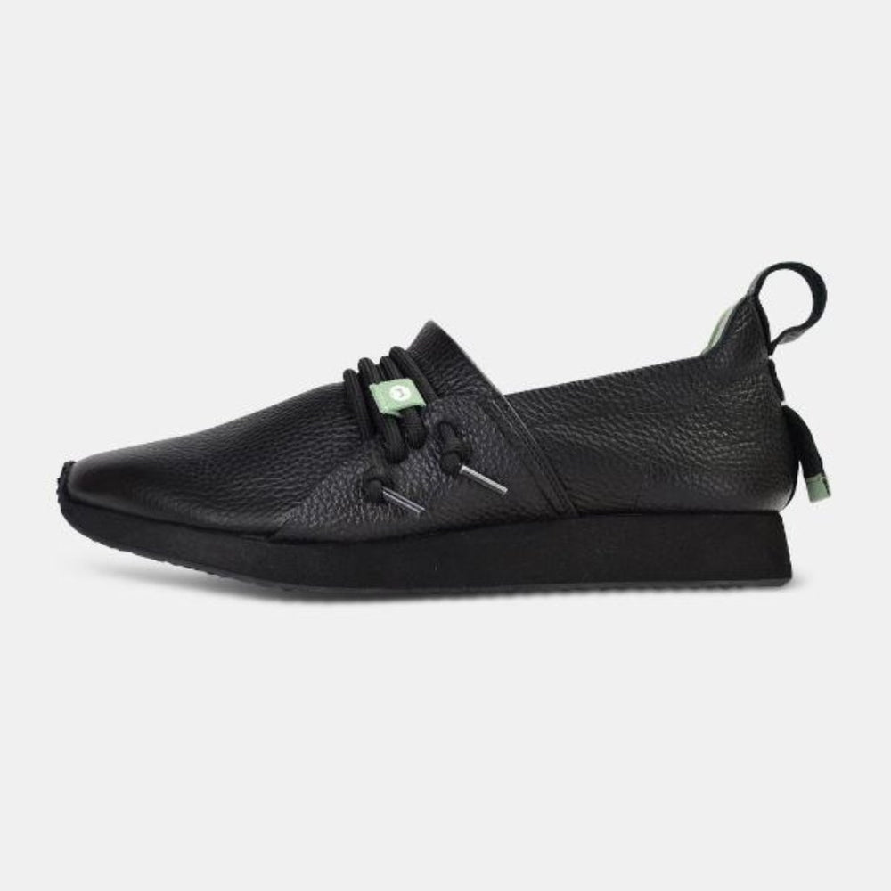 
                      
                        A side profile of a single Comunitymade "Mateo Stealth" shoe. The shoe is made of a black, pebbled leather with a black sole. Black round laces are cinched at the top. A black pull tab and a small mint green accent are visible at the heel.
                      
                    