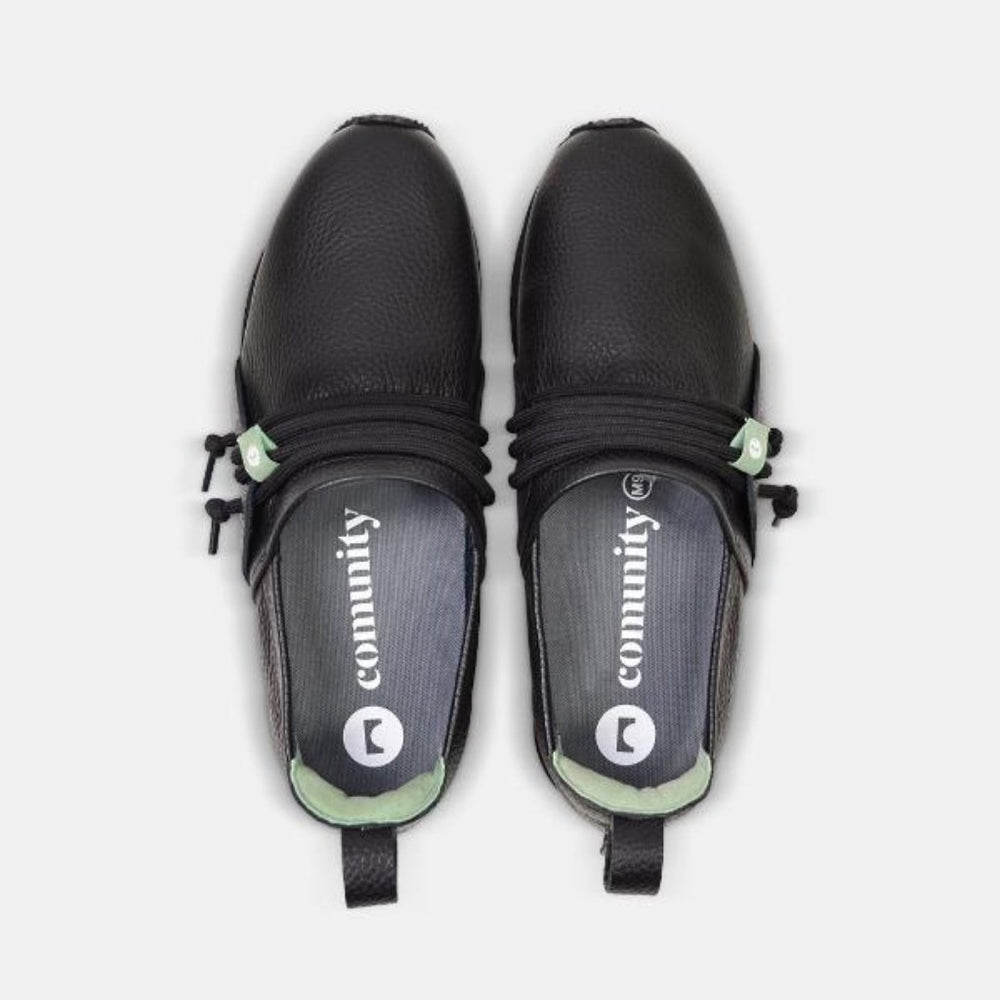 
                      
                        A top-down view of two Comunitymade "Mateo Stealth" shoes. The shoes are black, with a pebbled leather texture and black laces that are cinched with a mint green lace lock. The insoles are a dark gray with "comunity" and the brand's logo in white lettering.
                      
                    