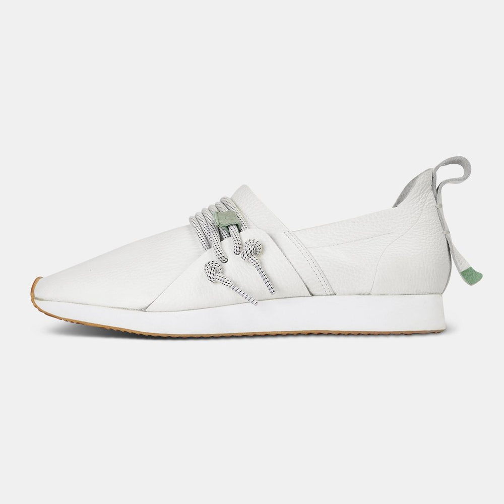 
                      
                        A side profile of a single white Comunitymade slip-on shoe. The shoe is made of a white, pebbled leather with thick gray and white speckled laces at the top. It has a flat white sole with a gum-colored accent at the toe.
                      
                    