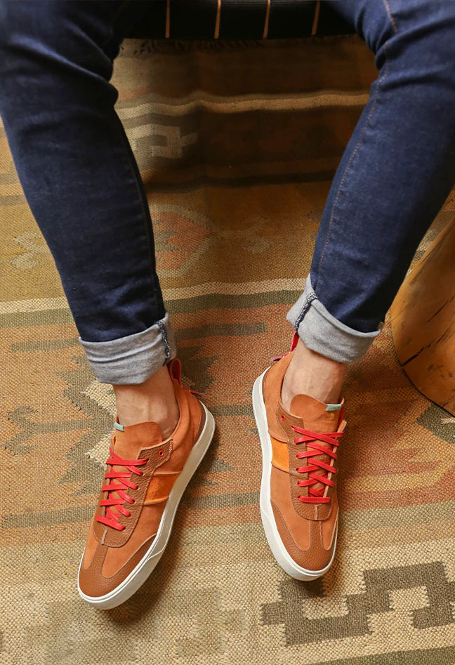 a pair of brown custom shoes made with suede and red laces