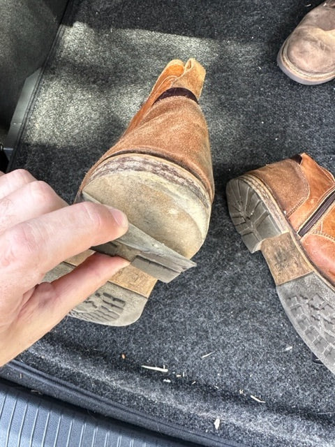 
                      
                        Picture of a brown hiking boot where the sole is falling off in the trunk of a care.  The shoe is in need of repair.
                      
                    