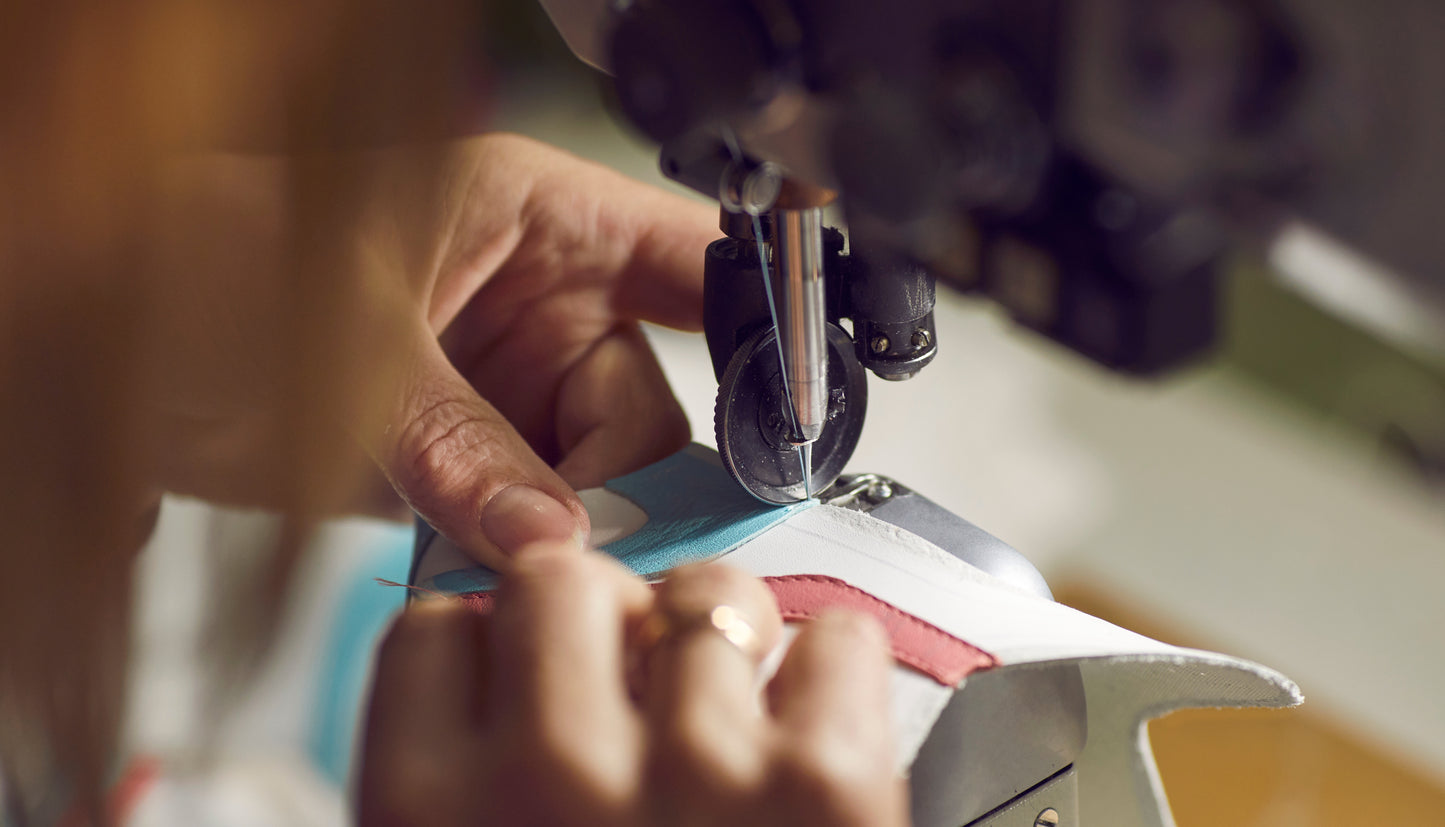 a shoe being stitched and guided by hand