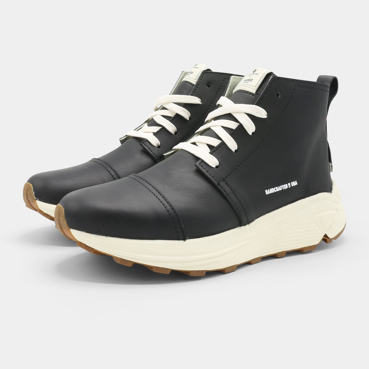 A black high-top urban utility chukka boot with white laces and a chunky white sole quarter view.
