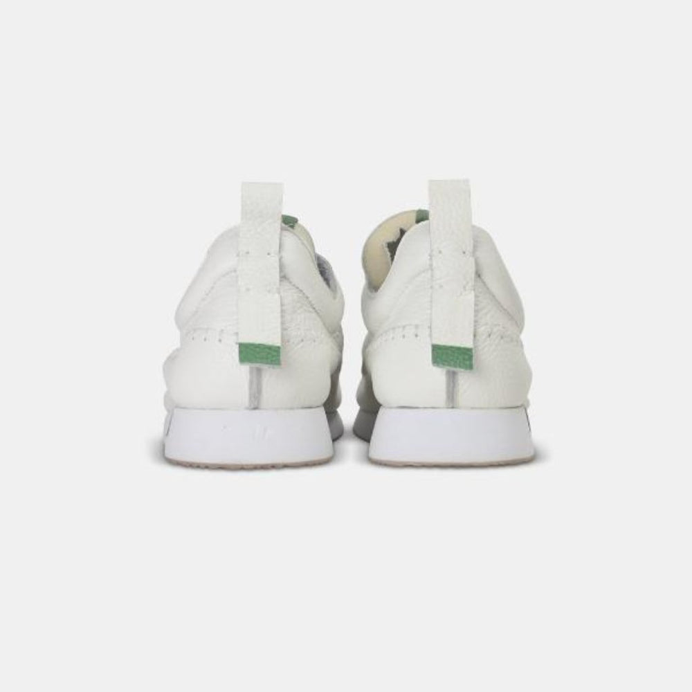 
                      
                        A rear view picture of a pair of white leather Comunitymade lace-up shoes. The shoe is made of a white leather and has white accent stitching around the entire shoe, plus a white heel pull tab with a light green accent.  The midsole is white with a gum rubber outsole.
                      
                    