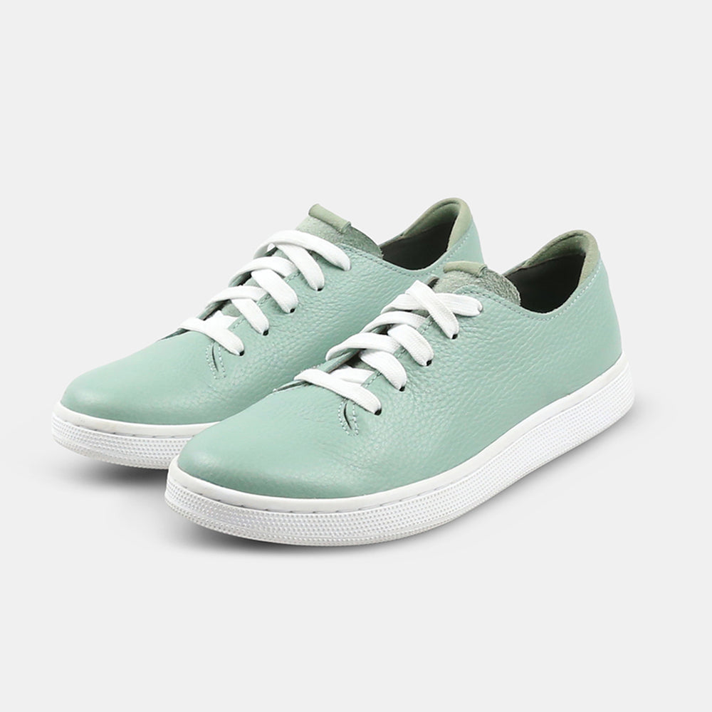 
                      
                        A quarter angle shot of pair of light green leather sneakers with a lace-up closure featuring flat white shoelaces, a white rubber cupsole and a green accent on the heel.
                      
                    
