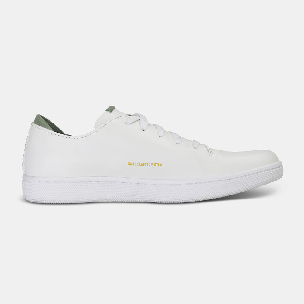 
                      
                        A medial profile shot of single white leather sneaker with a lace-up closure, featuring flat white shoelaces, white accent stitching on the heel, gold "Handcrafted in LA" printing on the instep and a white rubber cupsole.
                      
                    