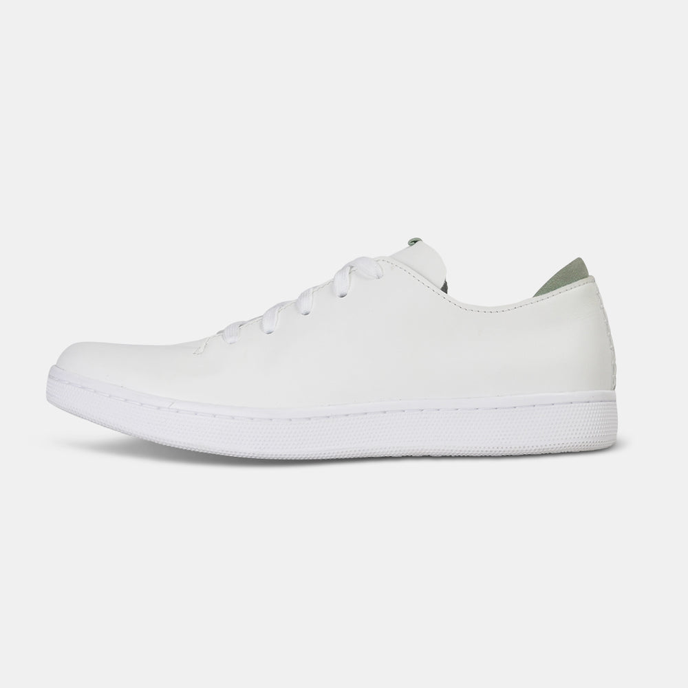 
                      
                        A profile shot of single white leather sneaker with a lace-up closure, featuring flat white shoelaces, a white rubber cupsole and a green accent on the heel.
                      
                    