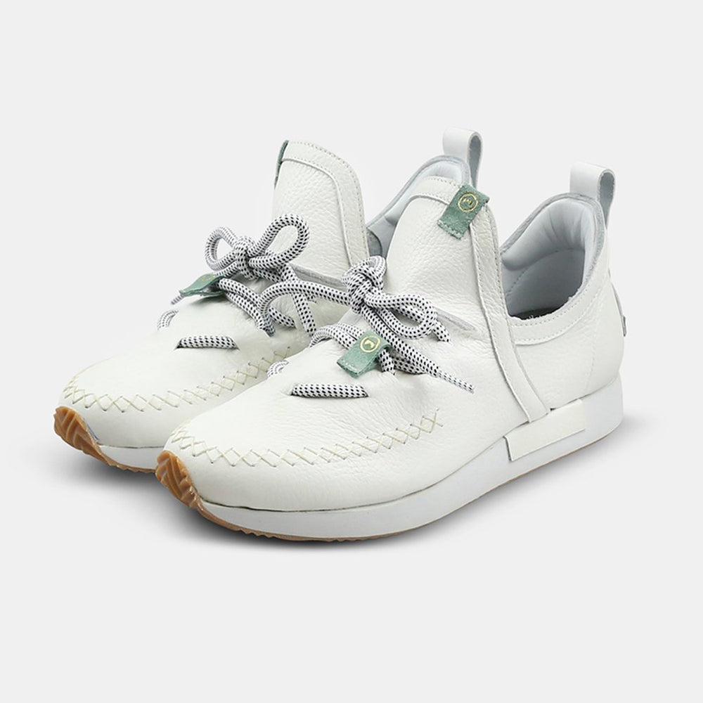 
                      
                        A quarter profile shot of a pair of casual white leather mid-cut slip-on shoe with unique stitch detailing on the toe and green branding accents.  Round white laces with heel loop pull tab and a white midsole and rubber outsole.
                      
                    