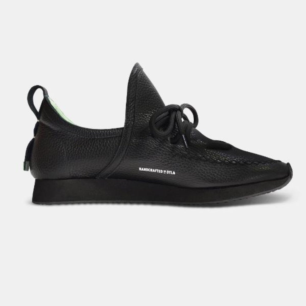 
                      
                        A single medial profile shot of a casual black leather mid-cut slip-on shoe with unique stitch detailing on the toe.  Round black laces with heel loop pull tab and a black midsole and black rubber outsole.
                      
                    