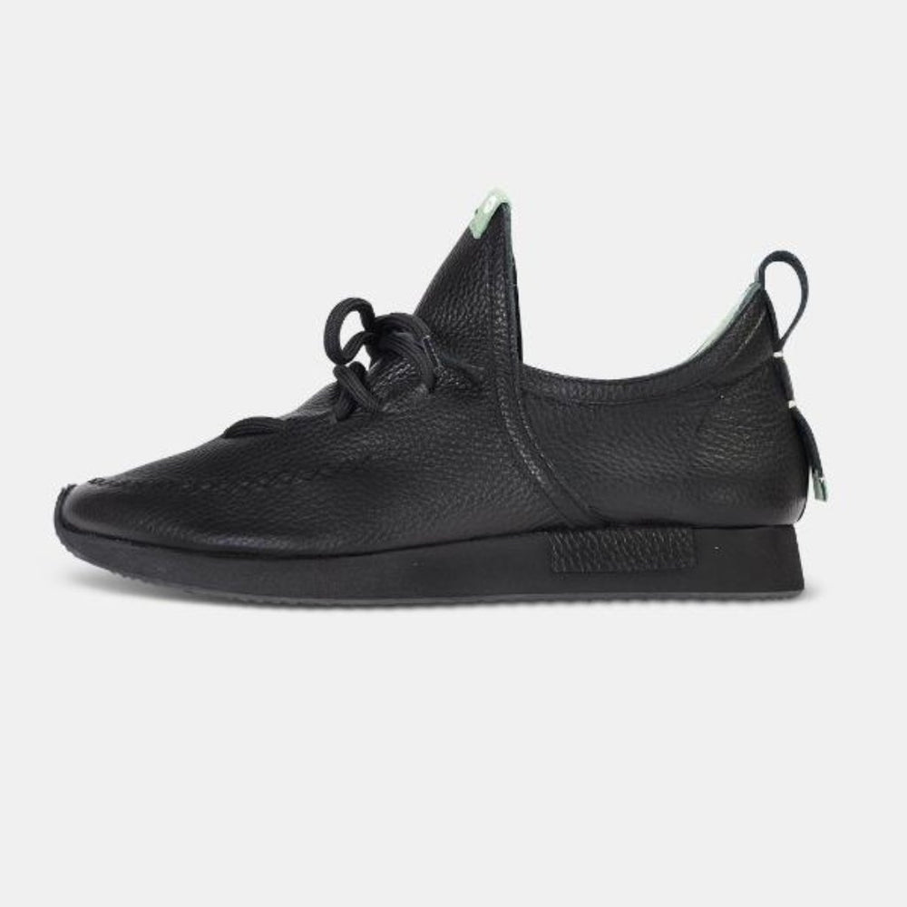 A single profile shot of a casual black leather mid-cut slip-on shoe with unique stitch detailing on the toe.  Round black laces with heel loop pull tab and a black midsole and black rubber outsole.