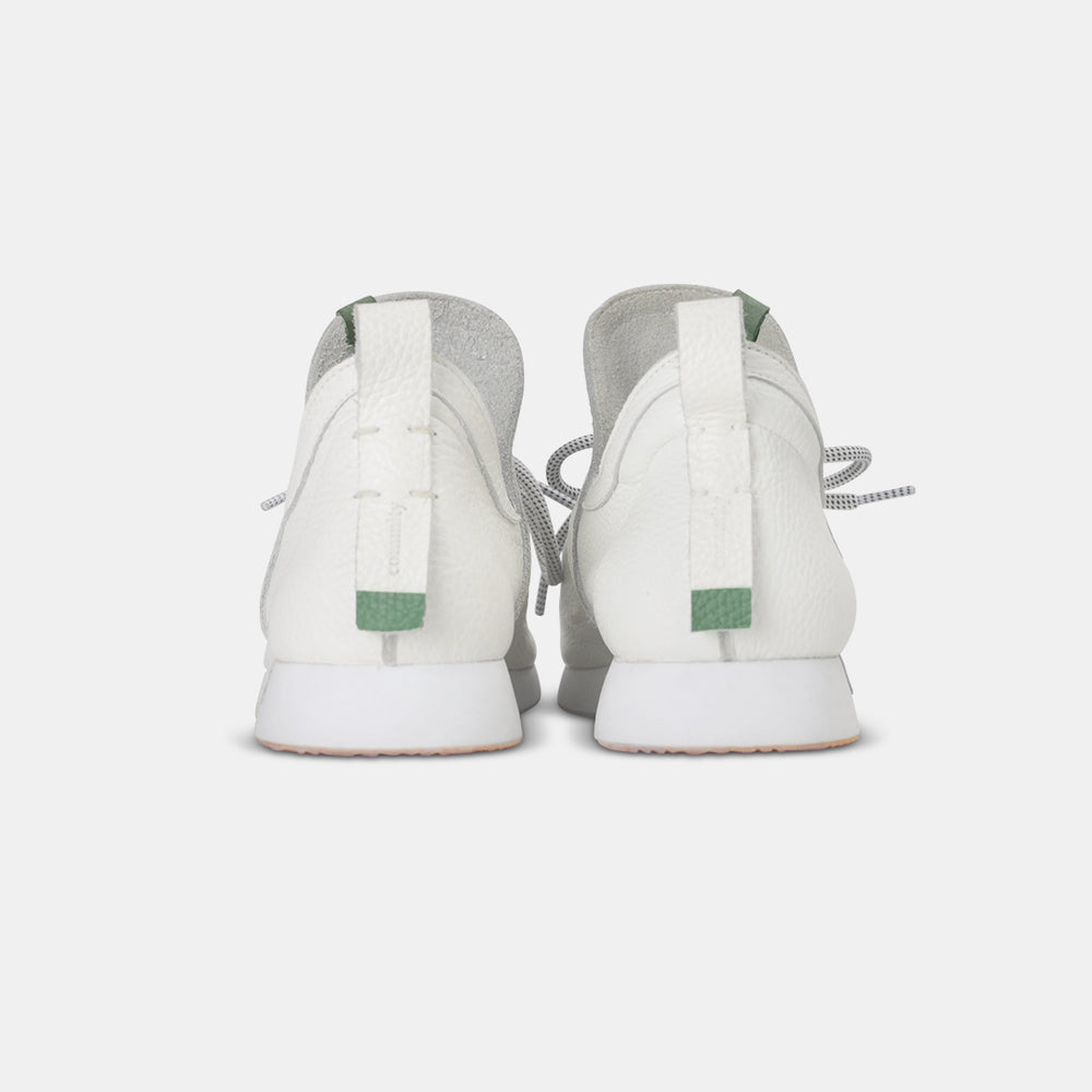 
                      
                        A rear view of a pair of casual white leather mid-cut slip-on shoe with a white heel loop pull tab with light green accents.  Showcases a white midsole with a gum rubber outsole.
                      
                    