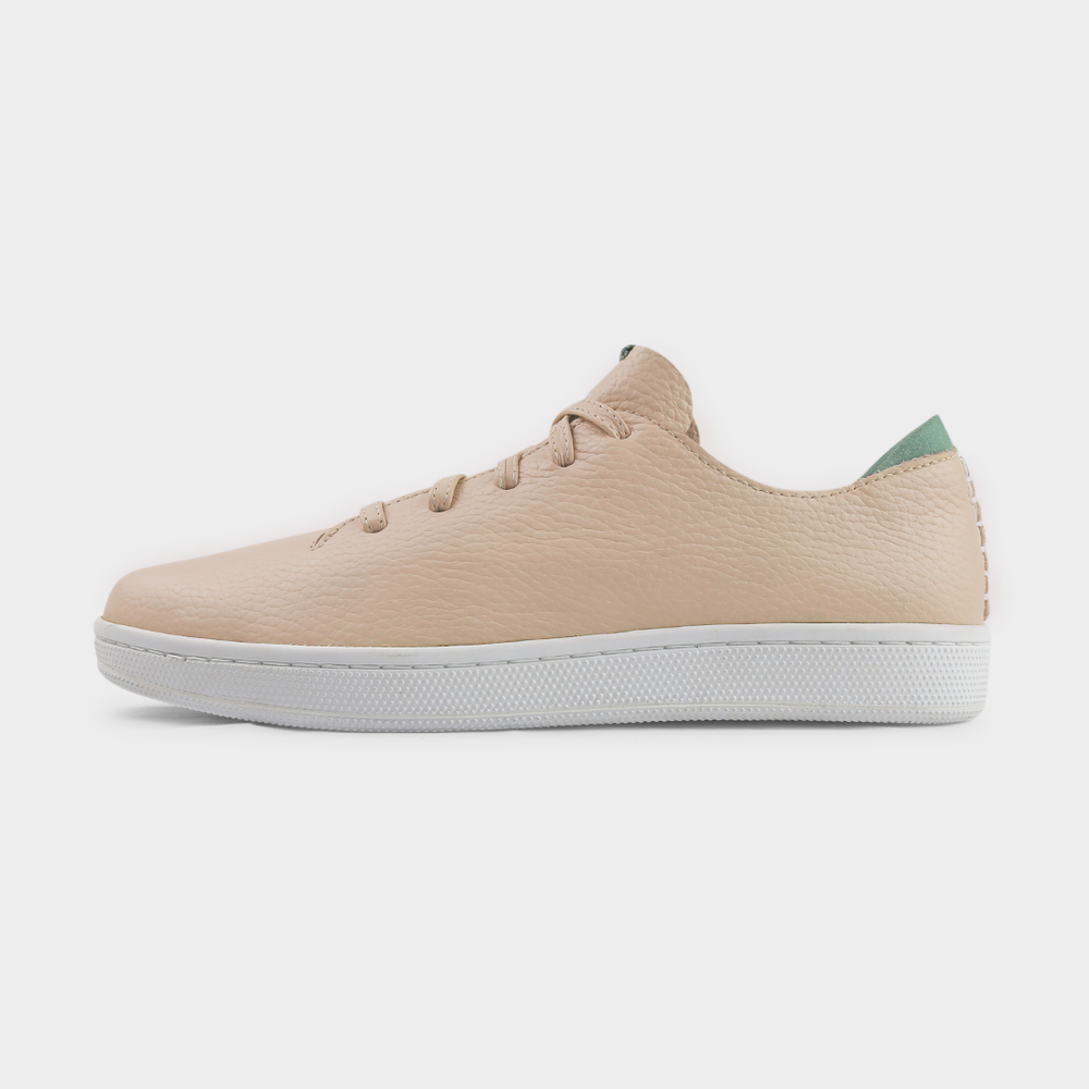 
                      
                        A profile shot of single nude beige leather sneaker with a lace-up closure, featuring nude beige leather shoelaces, a white rubber cupsole and a green accent on the heel.
                      
                    