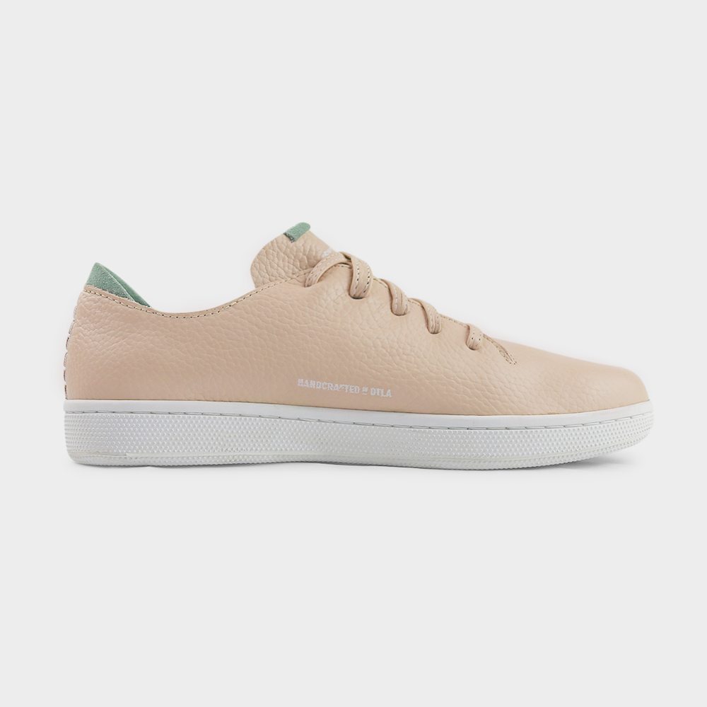 
                      
                        A medial profile shot of single nude beige leather sneaker with a lace-up closure, featuring flat nude beige leather shoelaces, white accent stitching on the heel, white "Handcrafted in LA" printing on the instep and a white rubber cupsole.
                      
                    