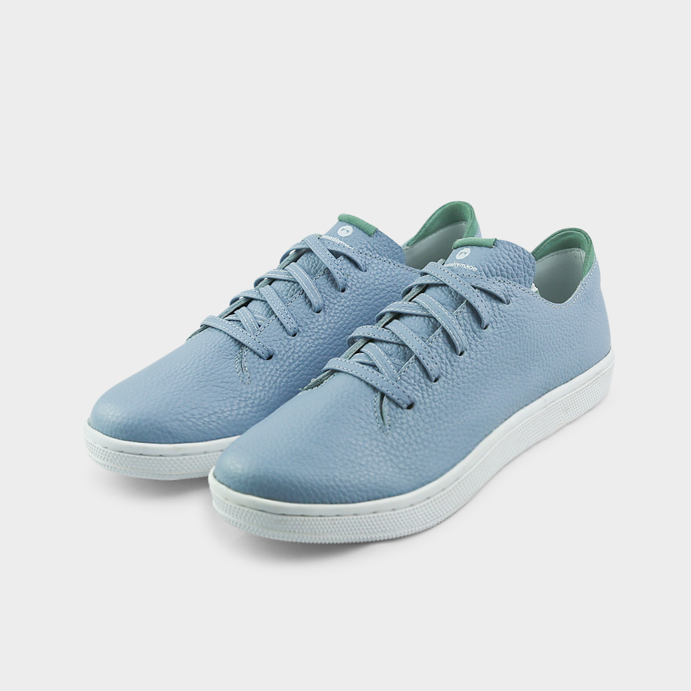 
                      
                        A quarter angle shot of pair of sky blue leather sneakers with a lace-up closure featuring flat sky blue leather shoelaces, a white rubber cupsole and a green accent on the heel.
                      
                    