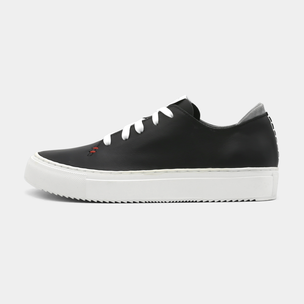 
                      
                        A black colored low-top sneaker with a white sole and laces, lateral view.
                      
                    