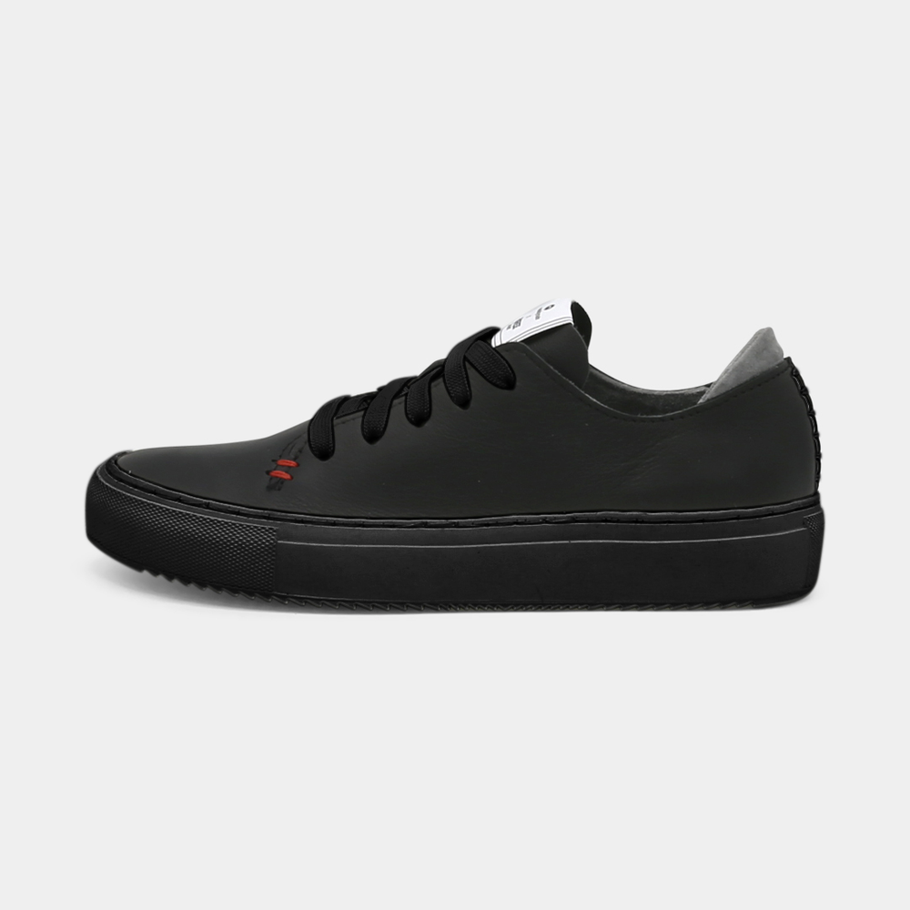 
                      
                        A black colored low-top sneaker with a black sole and laces, lateral view.
                      
                    