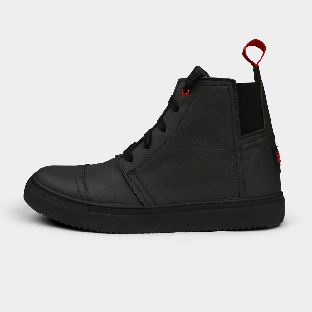 
                      
                        A black, high-top sneaker with a solid black rubber outsole, featuring laces and a red pull tab on the heel.
                      
                    