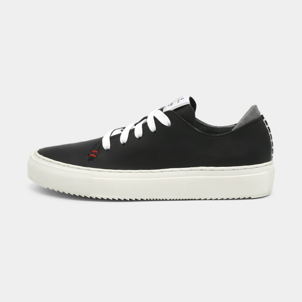 
                      
                        A black colored low-top sneaker with a white sole and laces, lateral view.
                      
                    