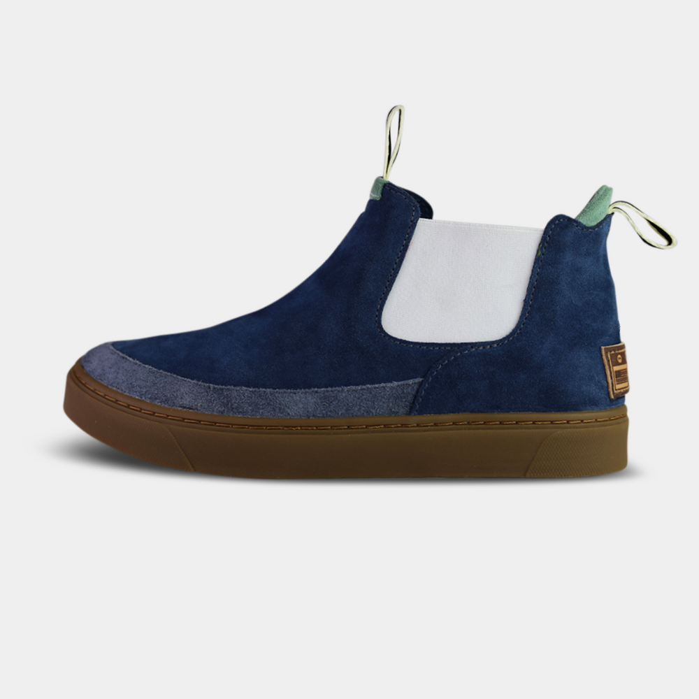 A navy blue and white mid-top sneaker with a brown sole and green details on the side.