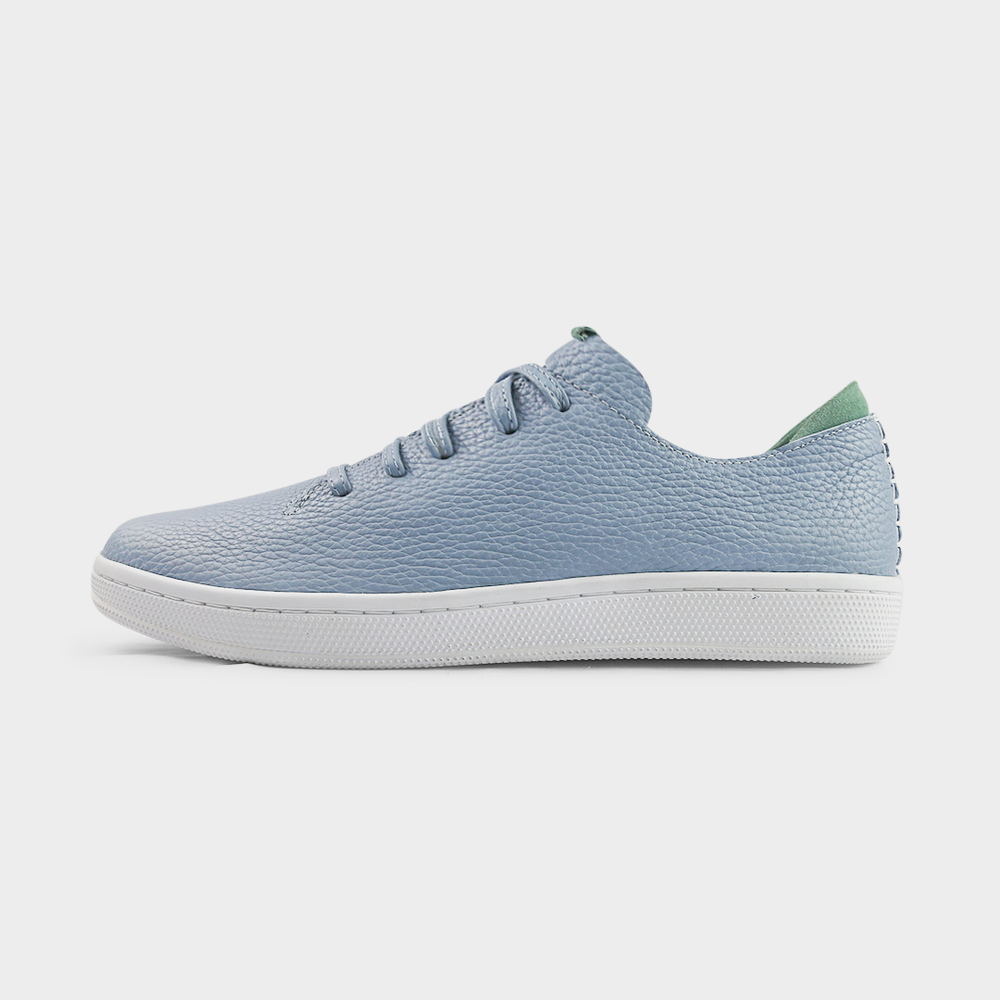 
                      
                        A profile shot of single sky blue leather sneaker with a lace-up closure, featuring sky blue leather shoelaces, a white rubber cupsole and a green accent on the heel.
                      
                    