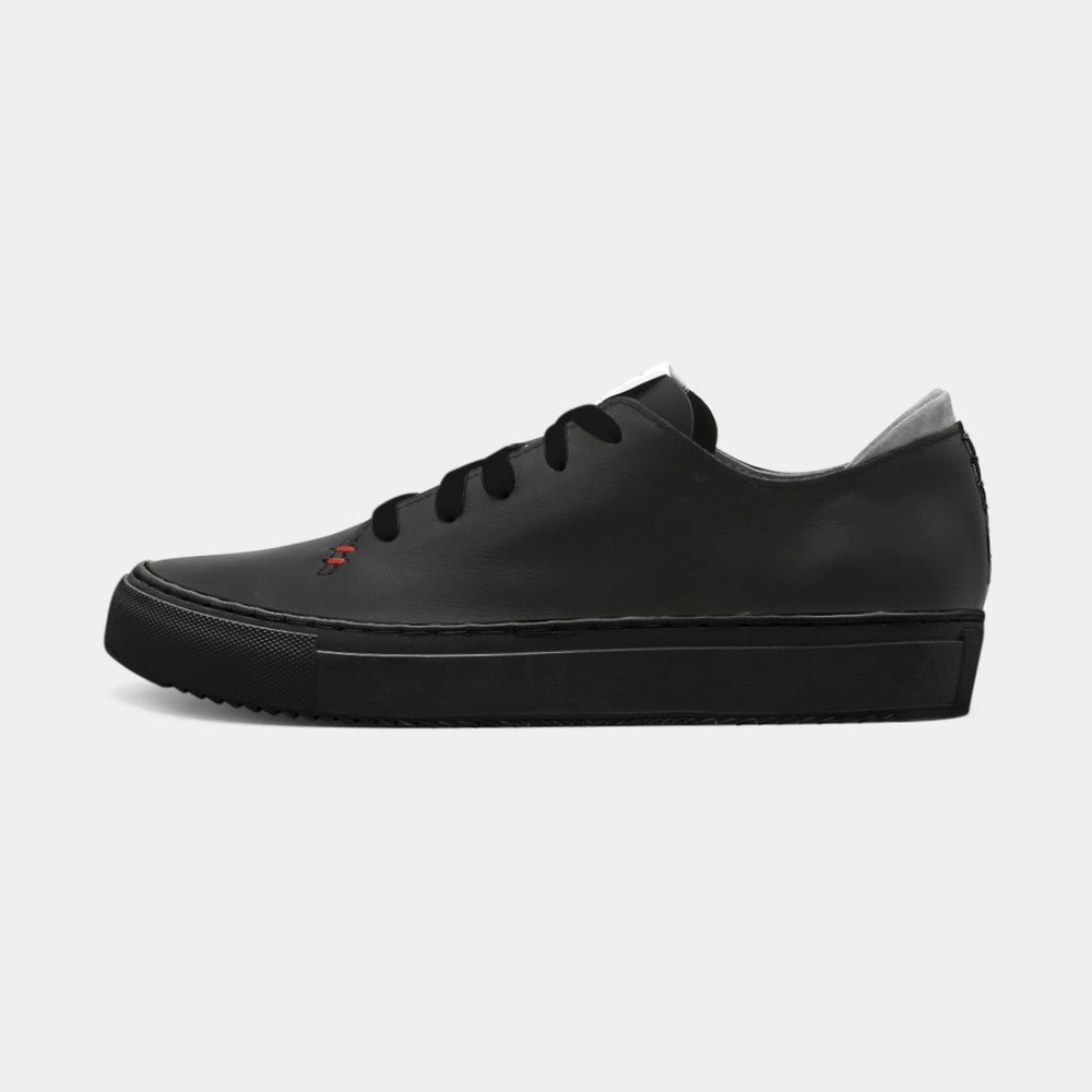 
                      
                        A black colored low-top sneaker with a black sole and laces, lateral view.
                      
                    