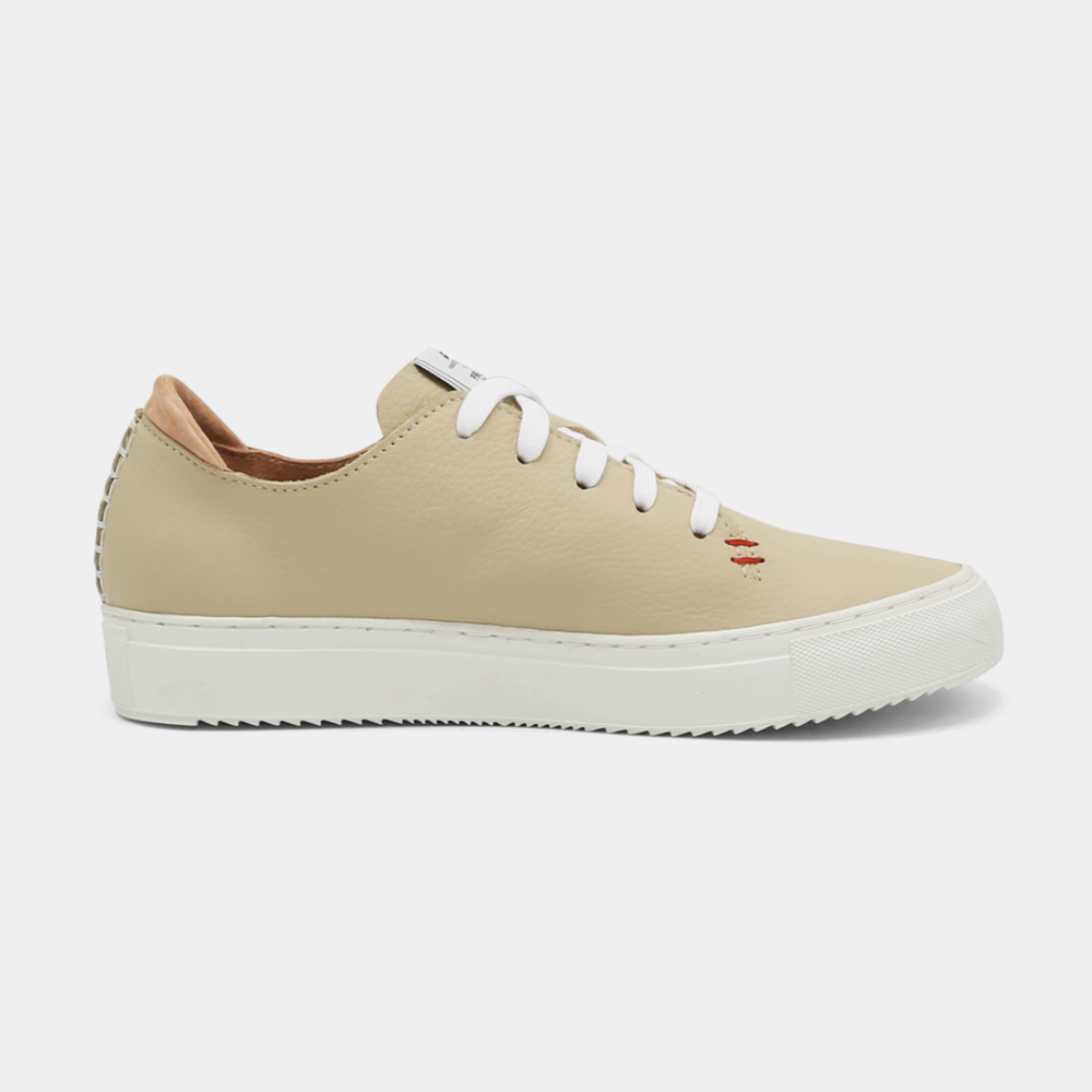 
                      
                        A cream colored low-top sneaker with a white sole and laces, medial view.
                      
                    