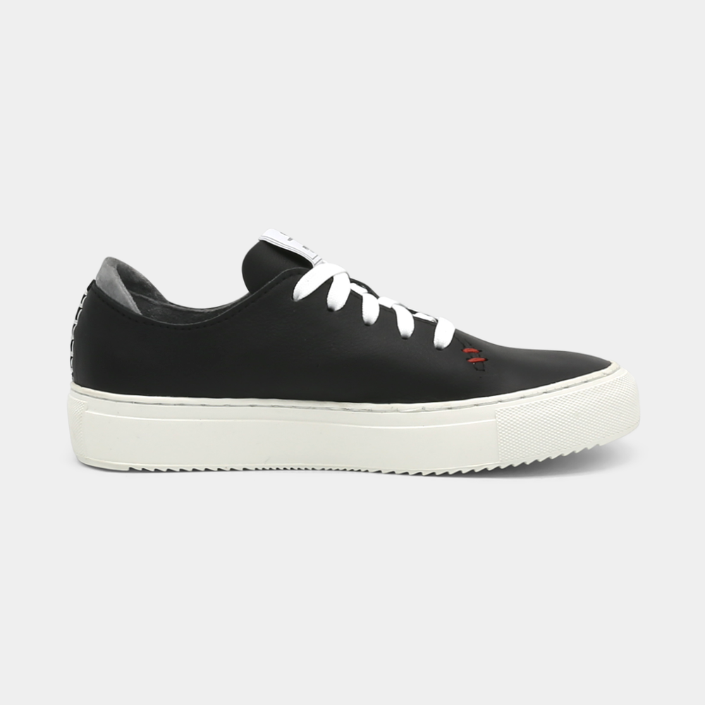 
                      
                        A black colored low-top sneaker with a white sole and laces, medial view.
                      
                    