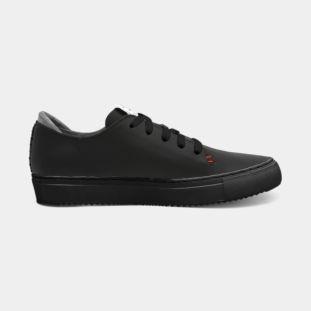 
                      
                        A black colored low-top sneaker with a black sole and laces, medial view.
                      
                    