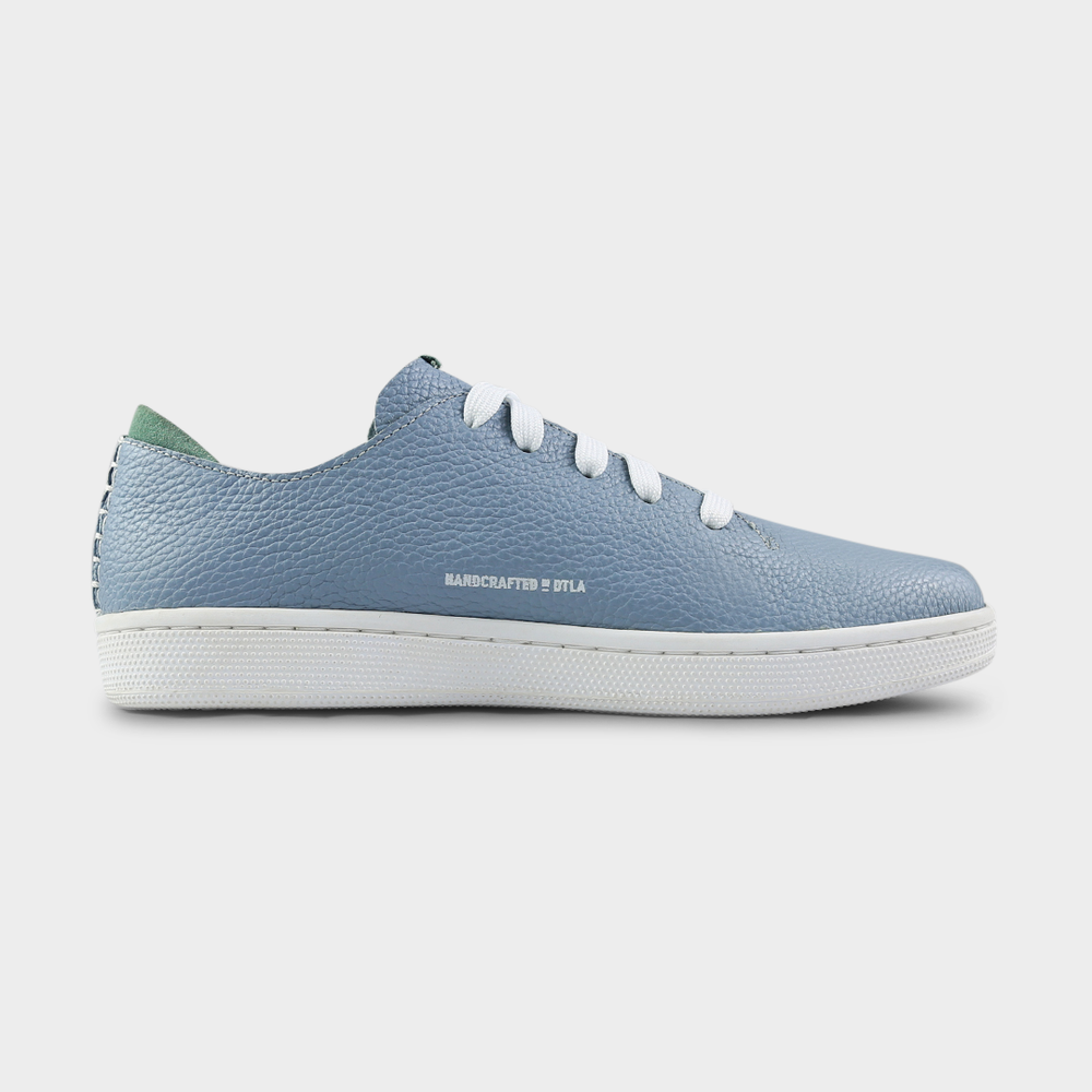 
                      
                        A medial profile shot of single sky blue leather sneaker with a lace-up closure, featuring flat white shoelaces, white accent stitching on the heel, white "Handcrafted in LA" printing on the instep and a white rubber cupsole.
                      
                    