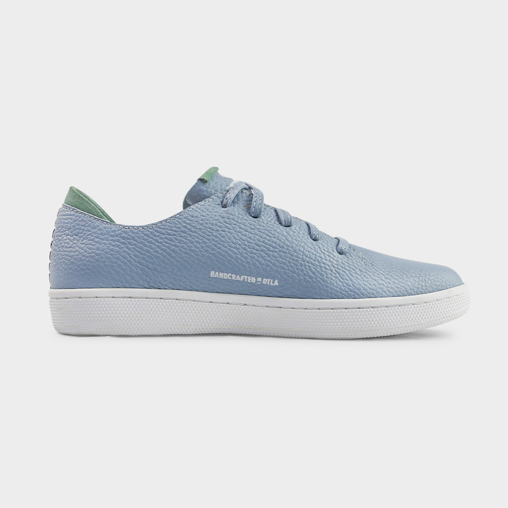 
                      
                        A medial profile shot of single sky blue leather sneaker with a lace-up closure, featuring flat sky blue leather shoelaces, white accent stitching on the heel, white "Handcrafted in LA" printing on the instep and a white rubber cupsole.
                      
                    