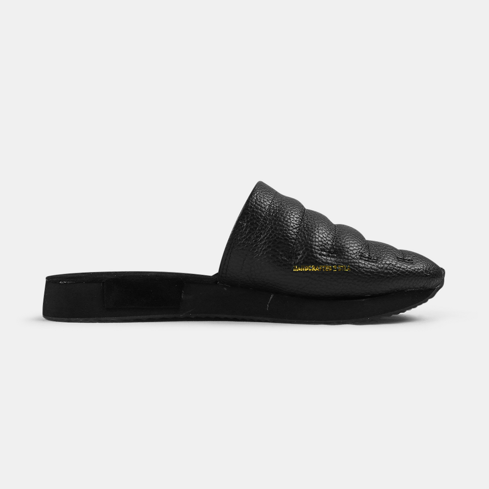 
                      
                        A men's Mateo slipper in black with a black rubber outsole, featuring a quilted design and a metallic accent medial view
                      
                    