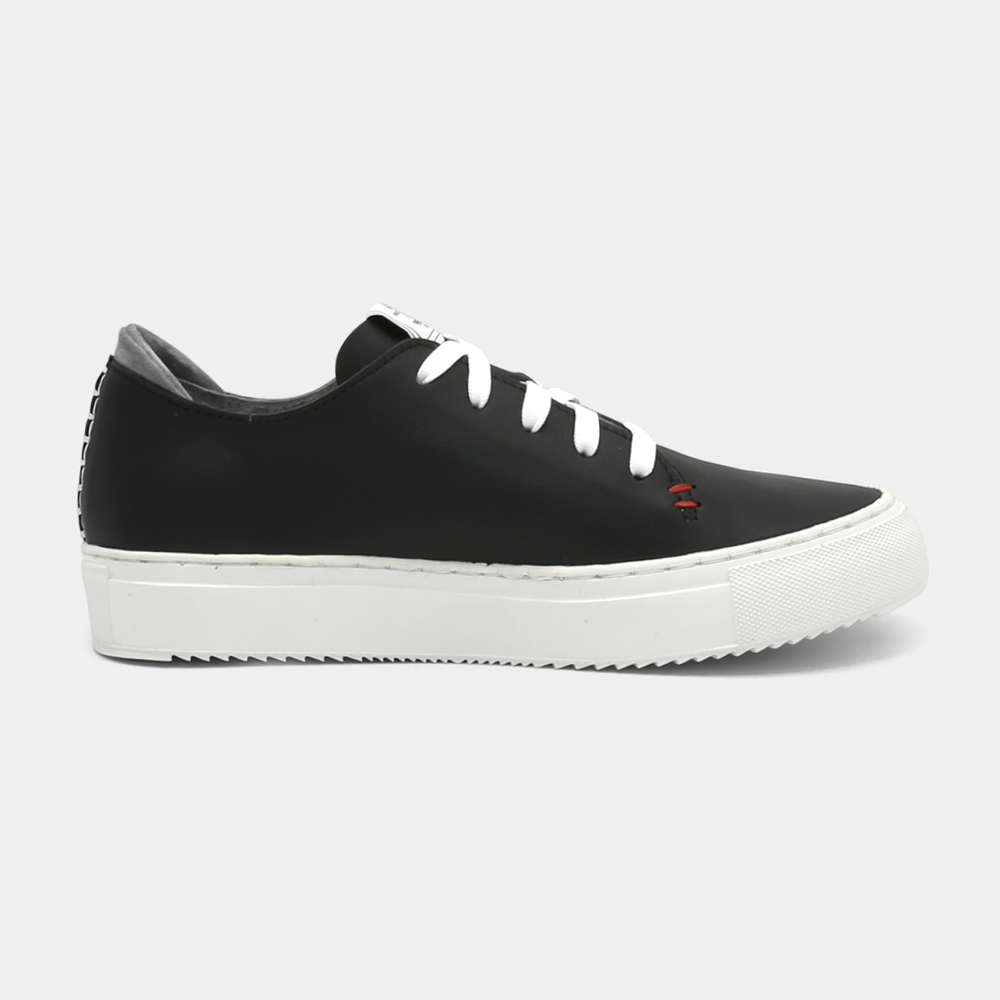 
                      
                        A black colored low-top sneaker with a white sole and laces, medial view.
                      
                    