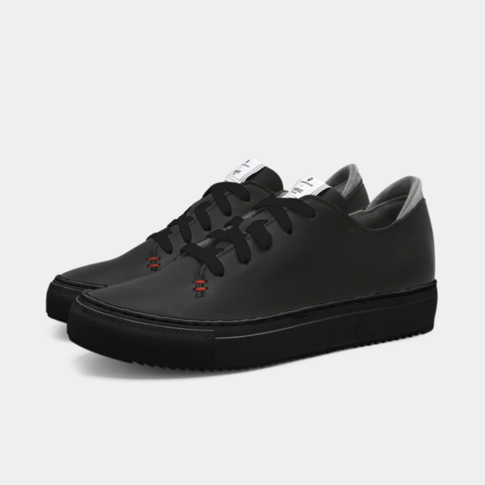 
                      
                        A black colored low-top sneaker with a black sole and laces, quarter view.
                      
                    