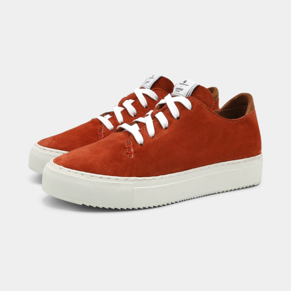 
                      
                        A rust colored low-top sneaker with a white sole and laces, quarter view.
                      
                    