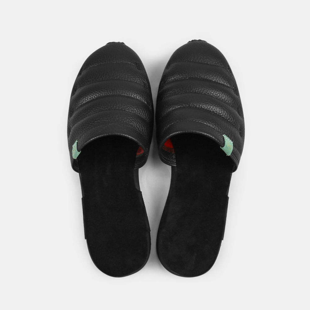 
                      
                        A men's Mateo slipper in black with a black rubber outsole, featuring a quilted design and a metallic accent top view
                      
                    