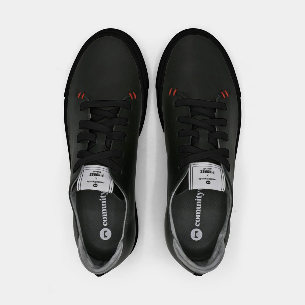 
                      
                        A black colored low-top sneaker with a black sole and laces, top view.
                      
                    