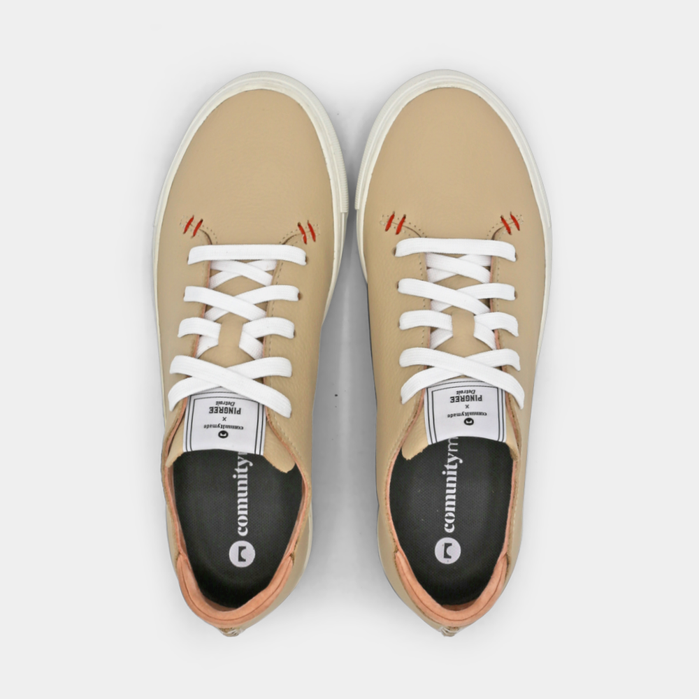 
                      
                        A cream colored low-top sneaker with a white sole and laces, top view.
                      
                    