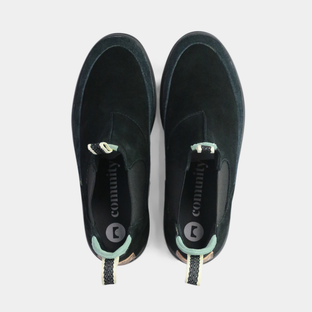 
                      
                        A pair of dark black suede ankle boots with a brown rubber sole. The boots feature a light brown leather logo tag with "DEVium" written on the back of each heel, a mint green elasticated panel, and a black and white striped pull tab at the back of the ankle.
                      
                    