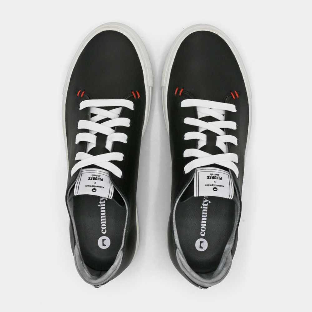 
                      
                        A black colored low-top sneaker with a white sole and laces, top view.
                      
                    