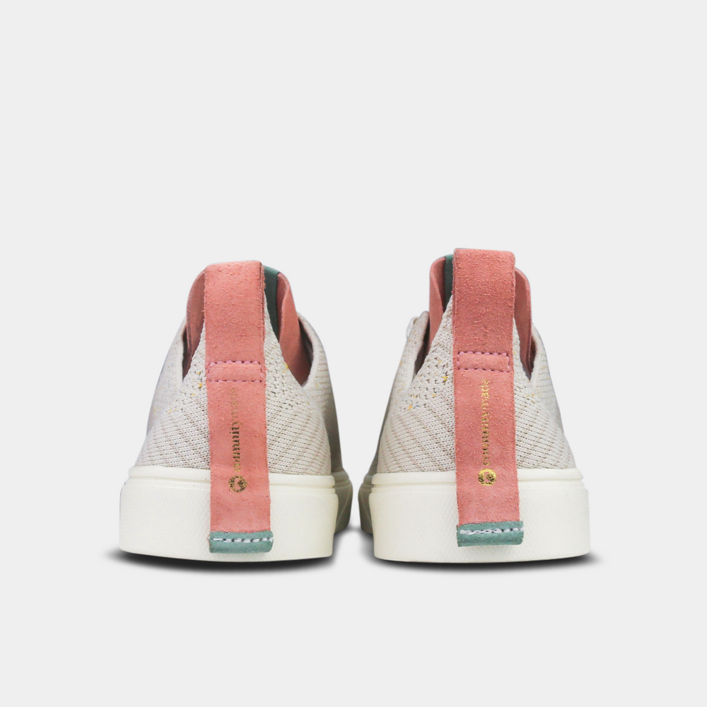 
                      
                        A pair of off-white knitted sneakers with light pink speckles. The shoes have white laces, a pale pink tongue, and a pink and white heel loop. The insoles are dark green with a white text logo and a circle.
                      
                    