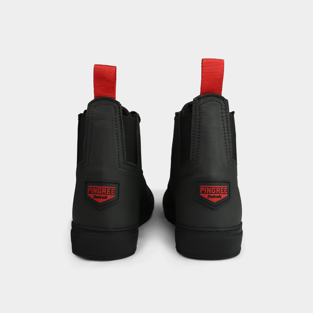 
                      
                        A head-on, product shot of the back of a pair of black high-top shoes. The shoes are made of black leather, with a white sole and a red loop on the back of the ankle. A red square with "PINGREE Detroit" written on it is visible on the heel of each shoe. The background is a solid light gray.
                      
                    