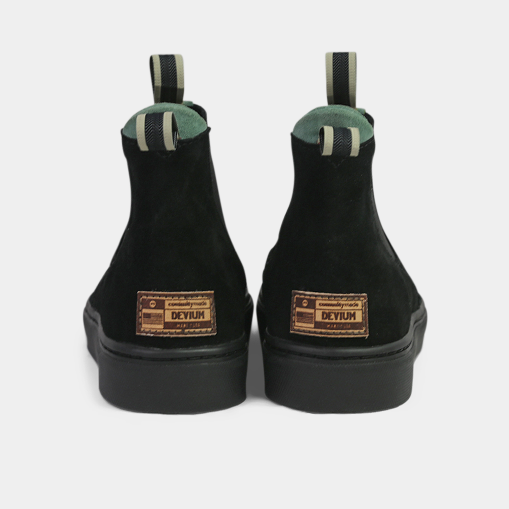 
                      
                        A pair of black ankle boots with a small leather logo tag on the back of each heel. The boots have a green elasticated panel and a striped brown and black pull tab at the back of the ankle.
                      
                    