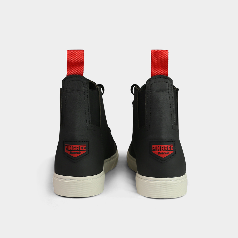 
                      
                        A head-on, product shot of the back of a pair of black high-top shoes. The shoes are made of black leather, with a white sole and a red loop on the back of the ankle. A red square with "PINGREE Detroit" written on it is visible on the heel of each shoe. The background is a solid light gray.
                      
                    