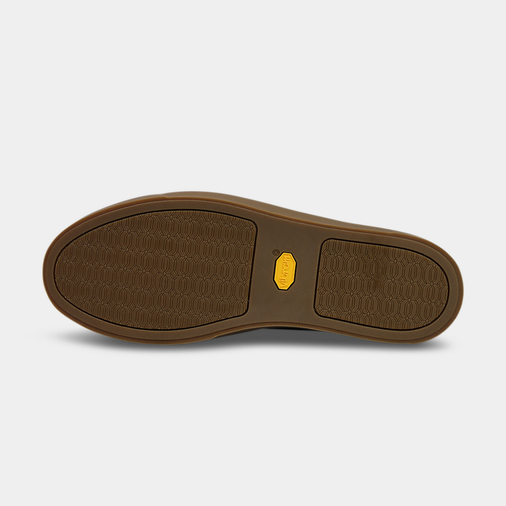 
                      
                        The bottom of a shoe with a brown rubber sole. The front and back of the sole have a repeating, circular pattern for grip, with a bright yellow oval logo in the center.
                      
                    