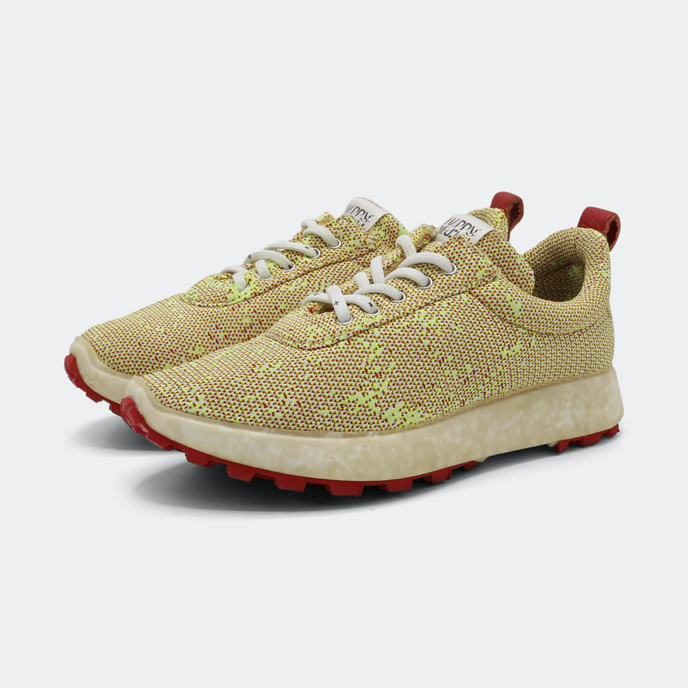 Sneakers with a yellow and pink print, featuring a textured upper and a white sole with red accents quarter view