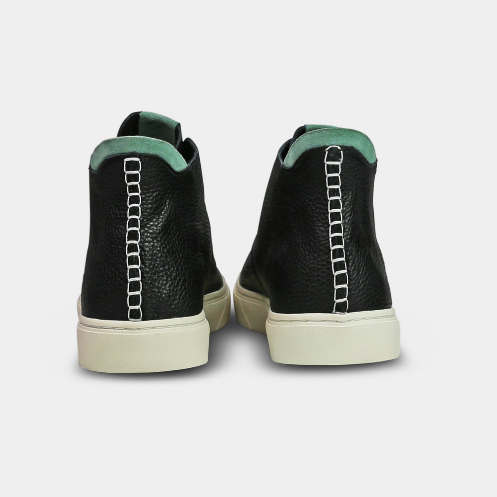 
                      
                        A black, mid-top sneaker with a leather upper, lace-up closure, and a white sole back view
                      
                    